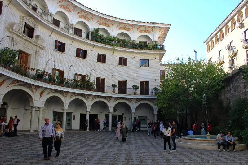 Pedestrians strolling around Plaza del Cabildo in Seville, Spain