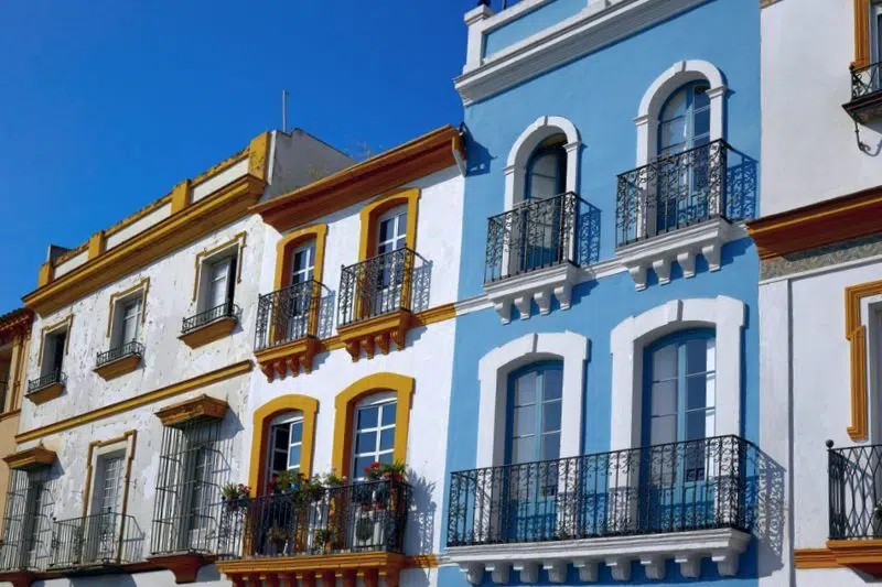 Charming blue, white, and yellow balconies in the Triana neighborhood of Seville